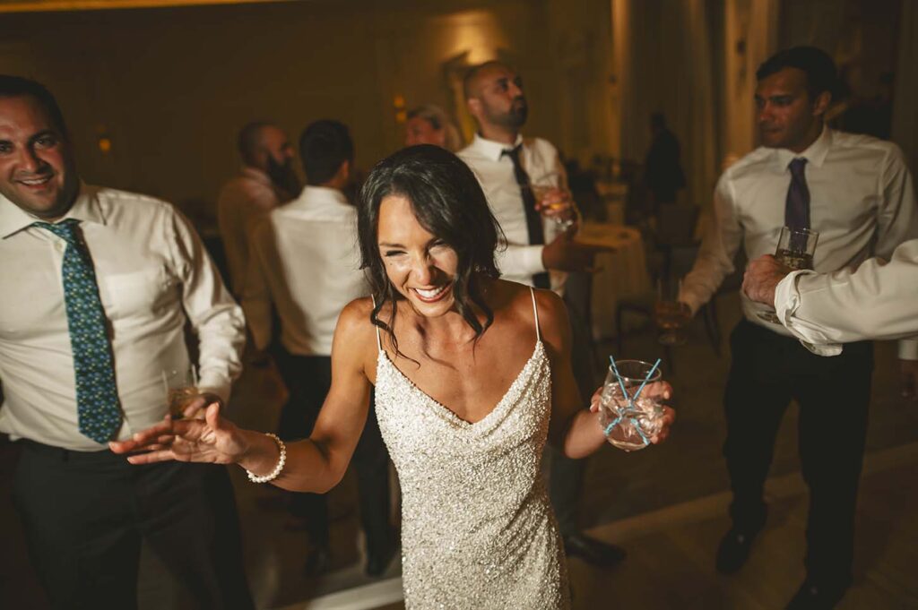 A bride is dancing with her friends at a wedding reception.