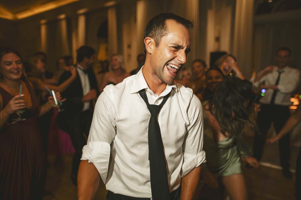 A man dancing on the dance floor at a wedding.