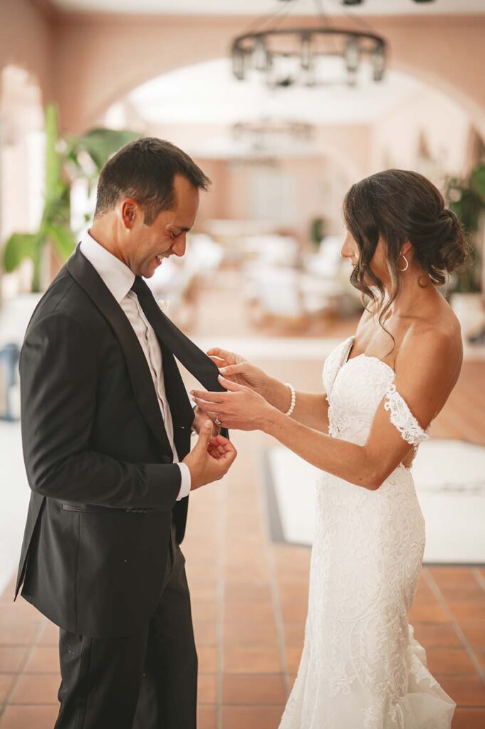A bride and groom putting on their wedding ties.