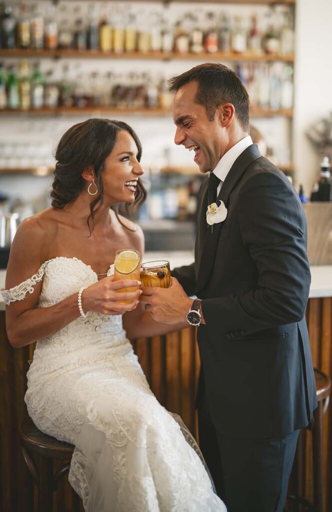 A bride and groom having a drink at a bar.